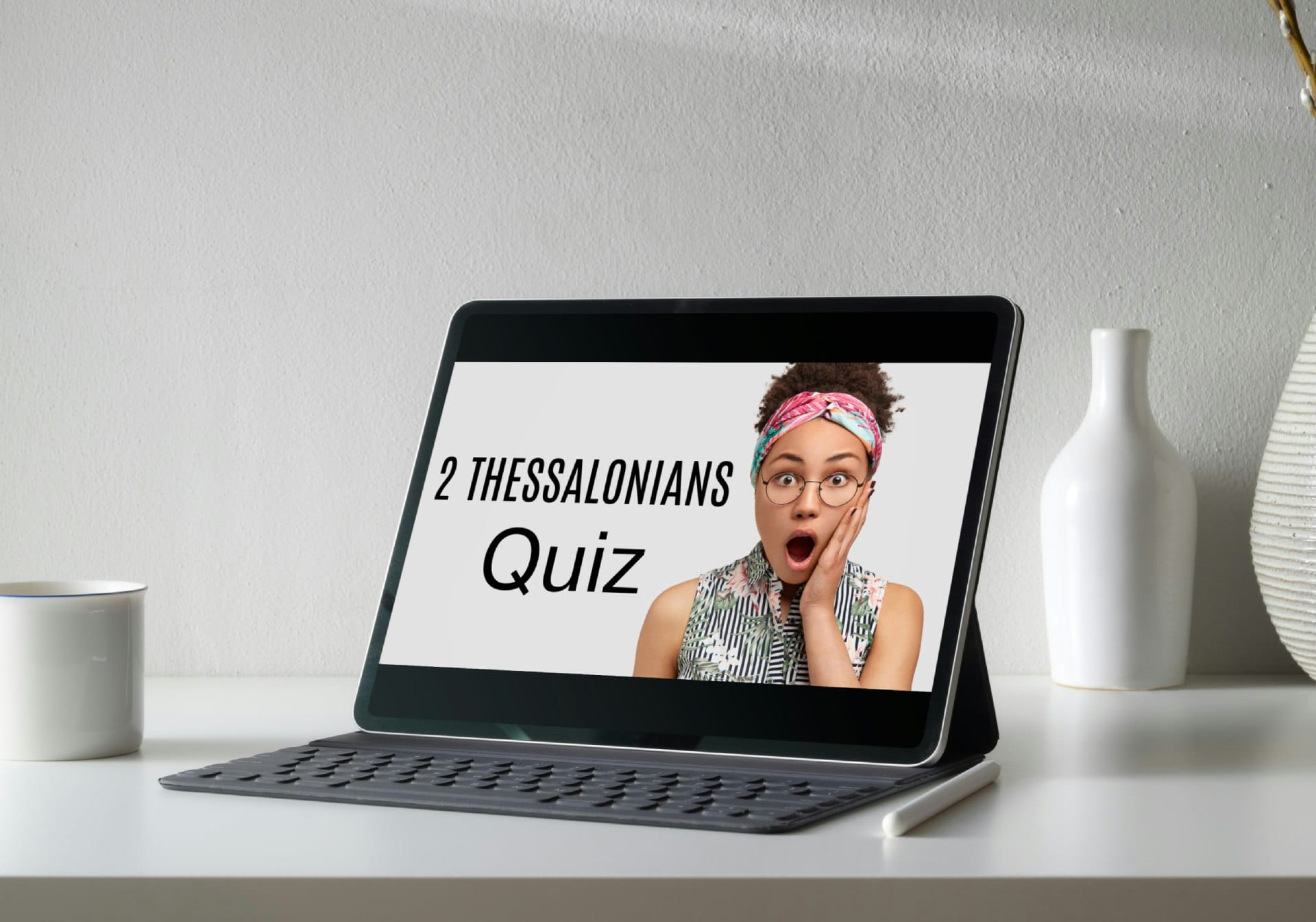 opened modern tablet, showing 2 Thessalonians quiz on screen, standing upright near a cup and a vase