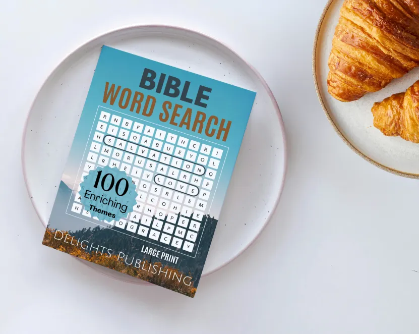 Home 3 A bible word search book on a plate next to a plate of croissants